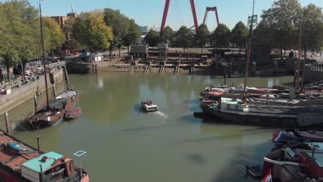 Drone-fly-over-of-the-harbor-of-Rotterdam,-Netherlands-where-boats-and-barges-are-docked