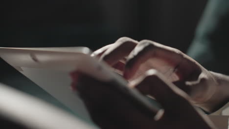 close-up of black youth's hand using tablet, tapping and interacting with screen in natural light. focus on fingers and touch gestures, emphasizing technology engagement and smooth screen interaction