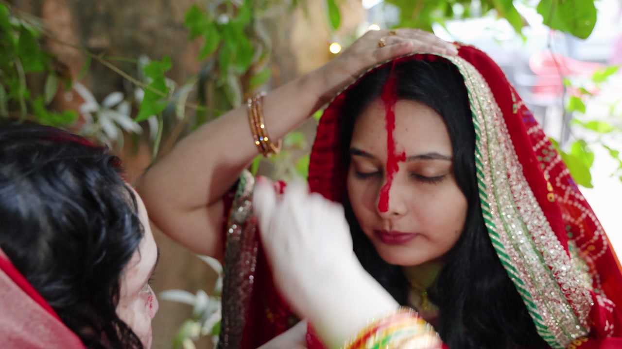devotee performing sacred sindoor or vermilion rituals on chhath puja celebration