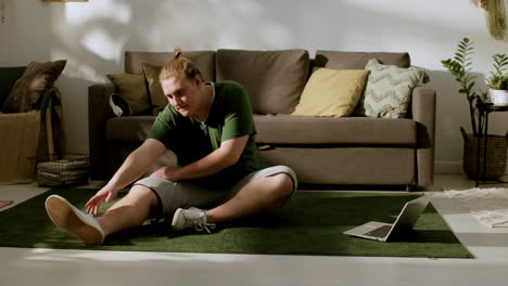 young guy stretching at home