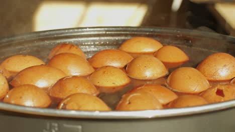 Chinese century eggs or tea egg in boiling water close-up. Chinese egg-based culinary dish made by preserving duck, chicken, or quail eggs in a mixture of clay, ash, salt, quicklime, and rice hulls for several weeks to several months.Korean mayak eggs or mayak gyeran are boiled eggs marinated in a f