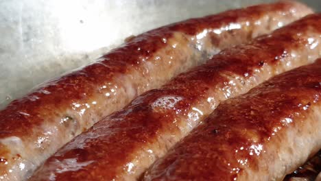 pure beef boerewors sausages frying till deliciously brown on a cast iron pan, olive oil and low fat healthy food with lots of protein