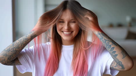 smiling young woman with pink hair and tattoos