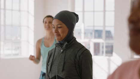 Feliz-Mujer-Musulmana-Bailando-Grupo-De-Personas-Sanas-Disfrutando-Del-Ejercicio-Practicando-Movimientos-De-Baile-Coreográficos-Divirtiéndose-En-El-Gimnasio