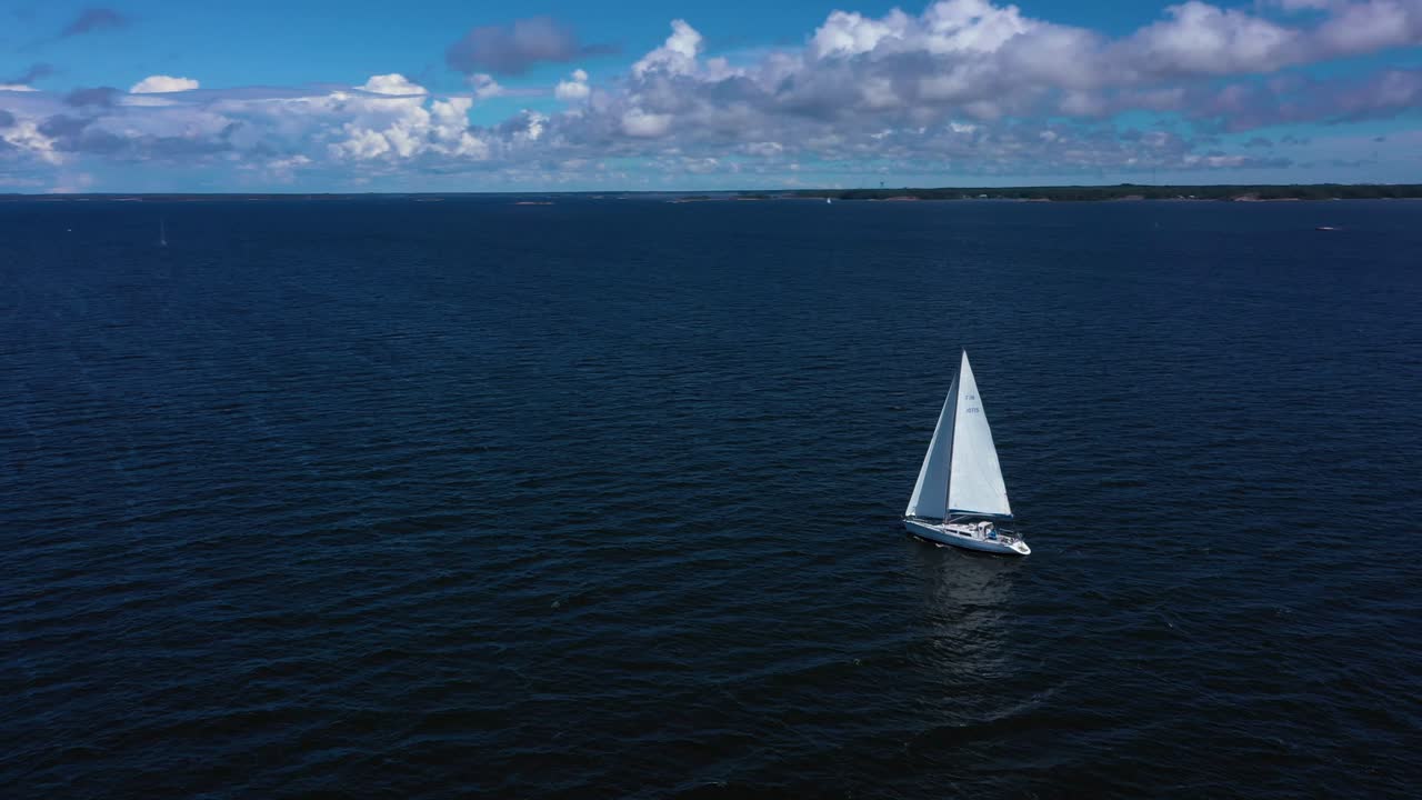 Aerial view around a white sail boat on the high seas, peaceful wind at the Finnish Gulf, warm, sunny, summer day, in Uusimaa, Finland - orbit, drone shot
