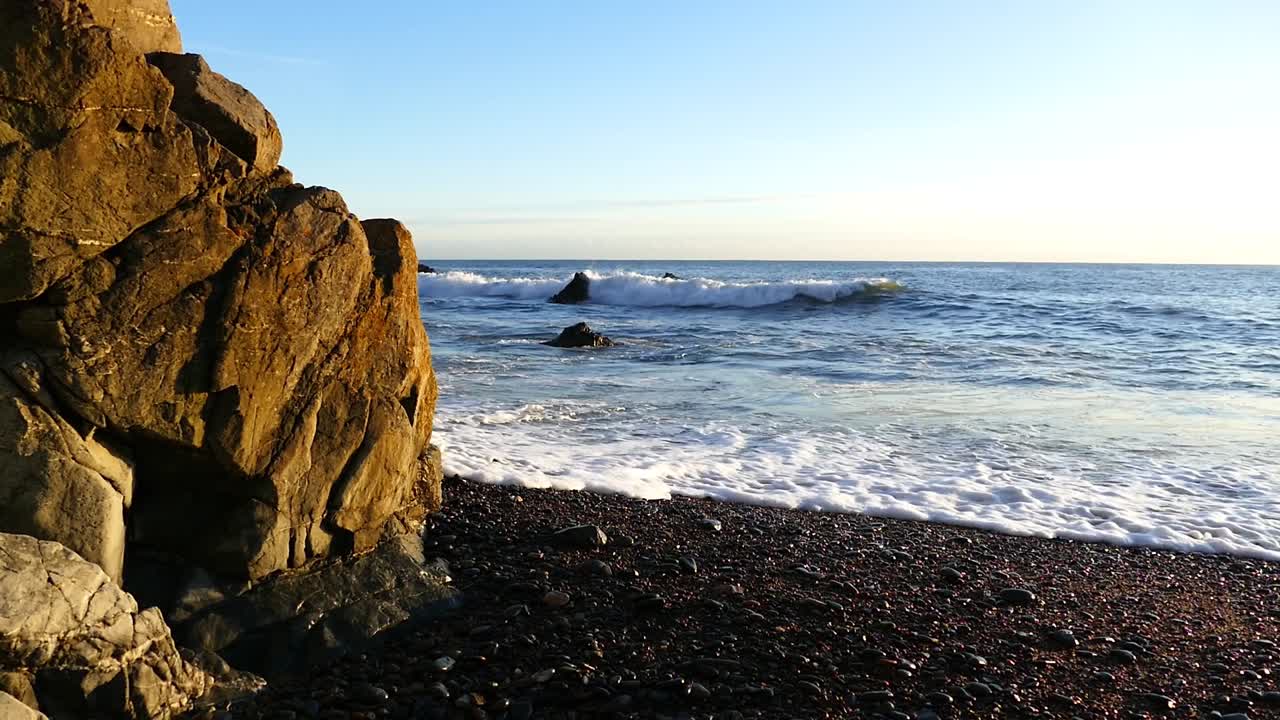 Irish coastline waves on shingle beach at golden hour winter sunshine Ireland epic locations Copper Coast Waterford