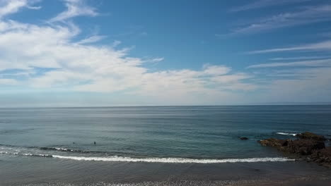 Seascape-at-Playa-Brujas-Mazatlan-with-two-surfers-in-water,-Mexico