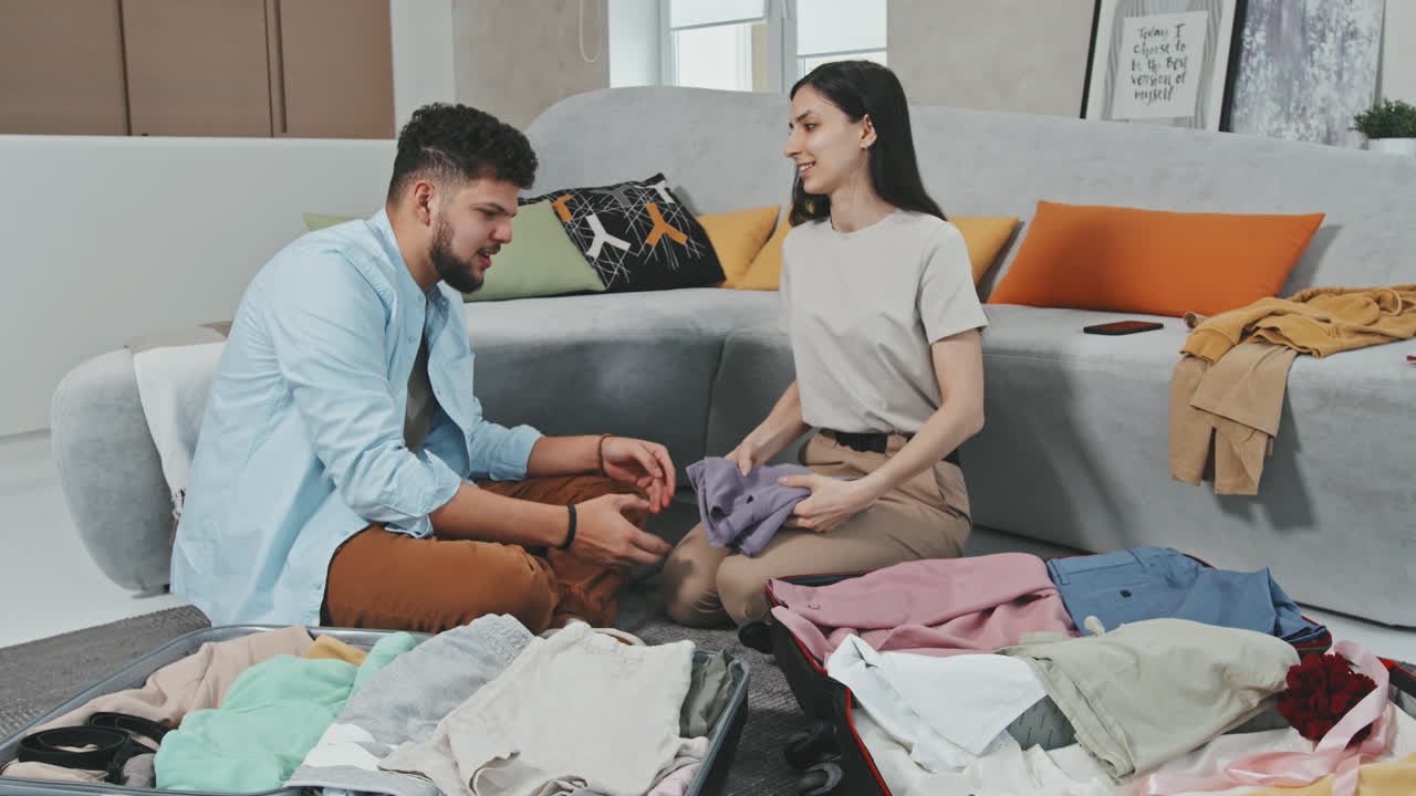 Young Couple Packing Suitcases Before Trip