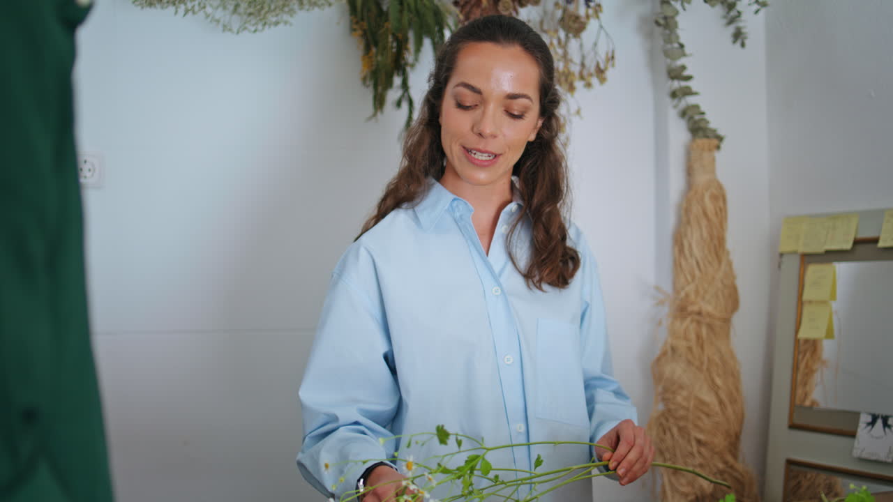 작은 사업 가게에서 즐거운 꽃 판매자 일. 꽃받침을 만드는 아름다운 여성