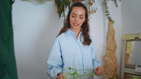 feliz vendedor de flores trabaja en una pequeña tienda de negocios. mujer hermosa haciendo ramo