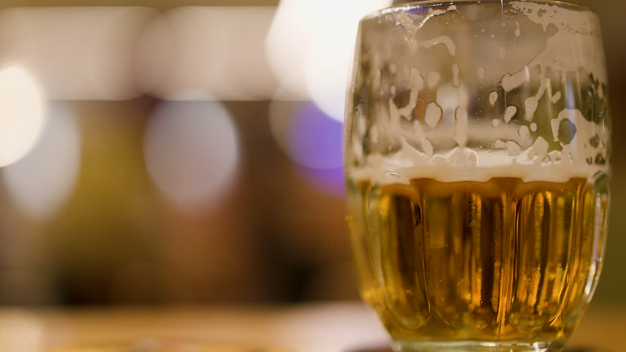 Closeup of foamy golden lager in glass mug at a pub in Pilsen, Czech Republic