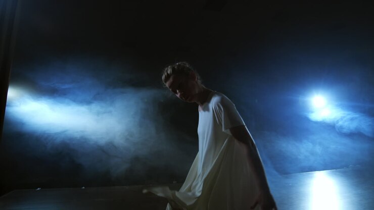 Slow-motion: female dancer on stage in smoke. Modern ballet barefoot on stage.