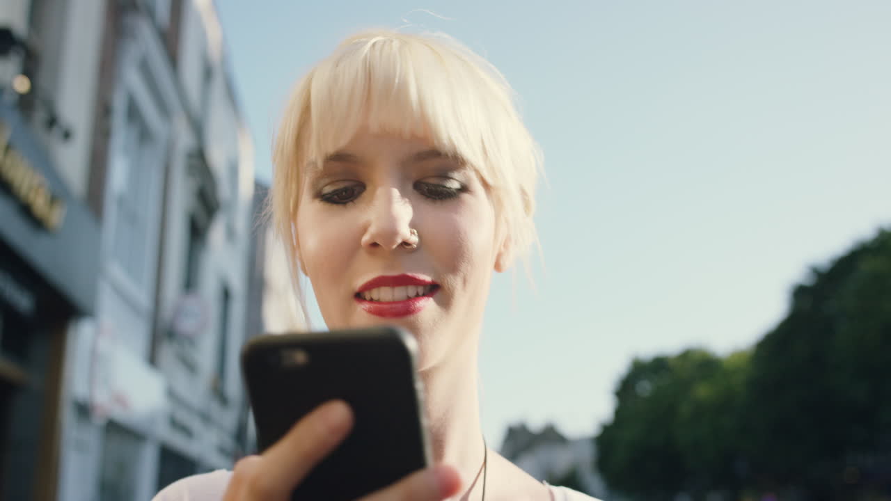 Smuk blondine bruger smartphone i byen.
