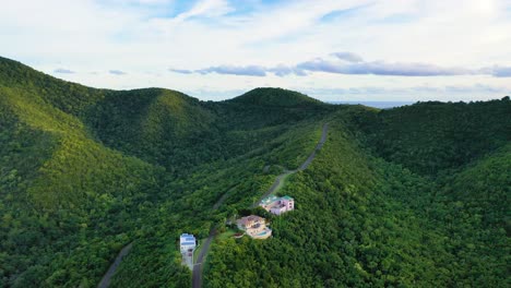 aerial footage of st. croix showcases elegant homes placed sparingly within the thick jungle, nestled on lush hillsides with wide island views and rugged caribbean mountains rising in the distance