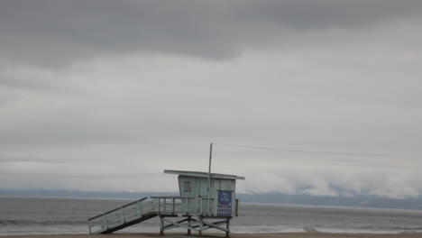 empty lifeguard tower abandoned, waves crash on shore, foggy gloomy days, slow motion