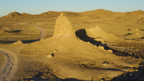 Rotating-aerial-view-of-one-of-the-pinnacles-at-the-Trona-Pinnacles-in-the-Mojave-Desert-during-a-bright-yellow-sunrise