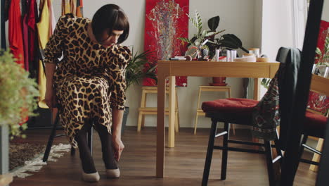 transgender man in dress putting on heels