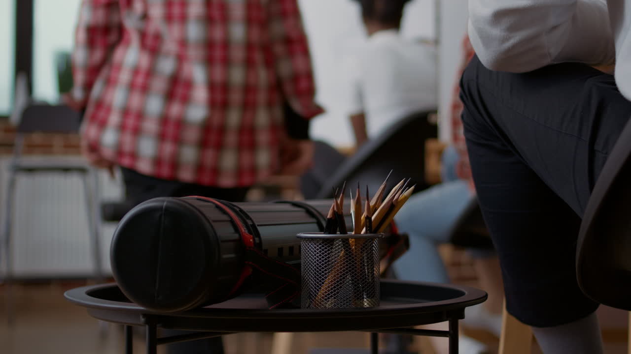 Student using colorful pencils on table to draw sketch in art class