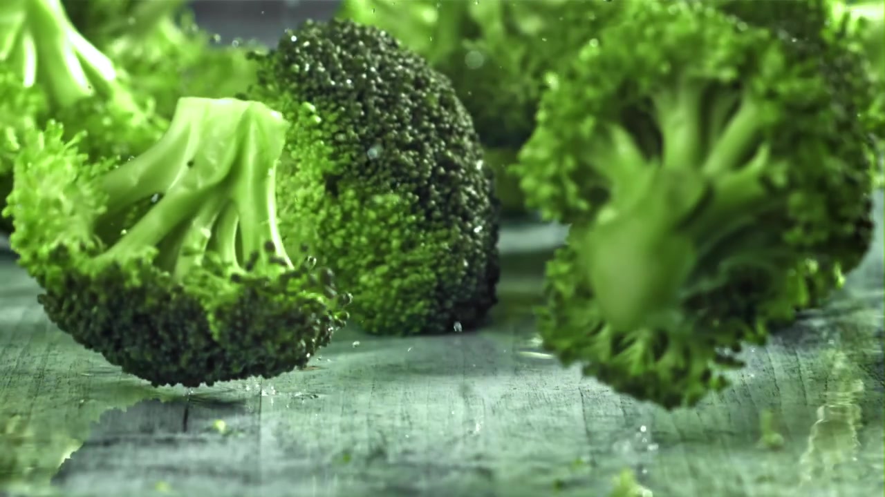 Slow Motion of Fresh Broccoli Falling with Water Splashes