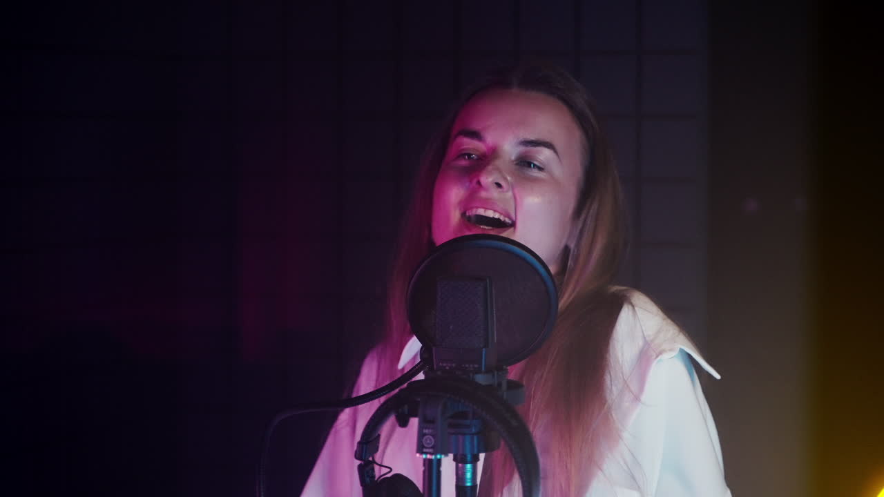 Woman Singing into Microphone in Recording Studio