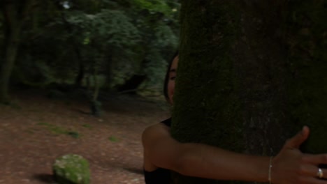 Female-hands-hugging-big-tree,-moving-to-reveal-beautiful-woman