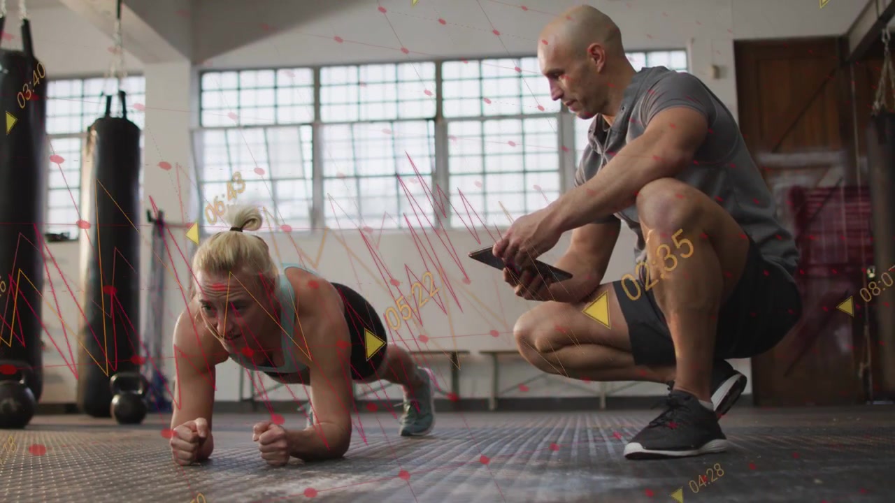 Woman Planking While Personal Trainer Monitors Progress on Tablet
