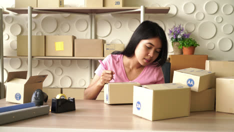 asian women business owner working at home with packing box on workplace