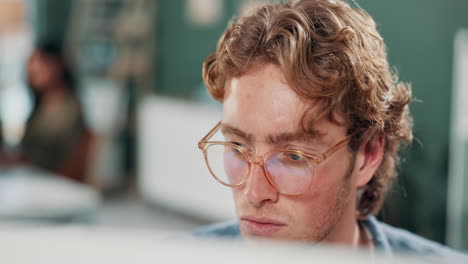 man with curly hair wearing glasses