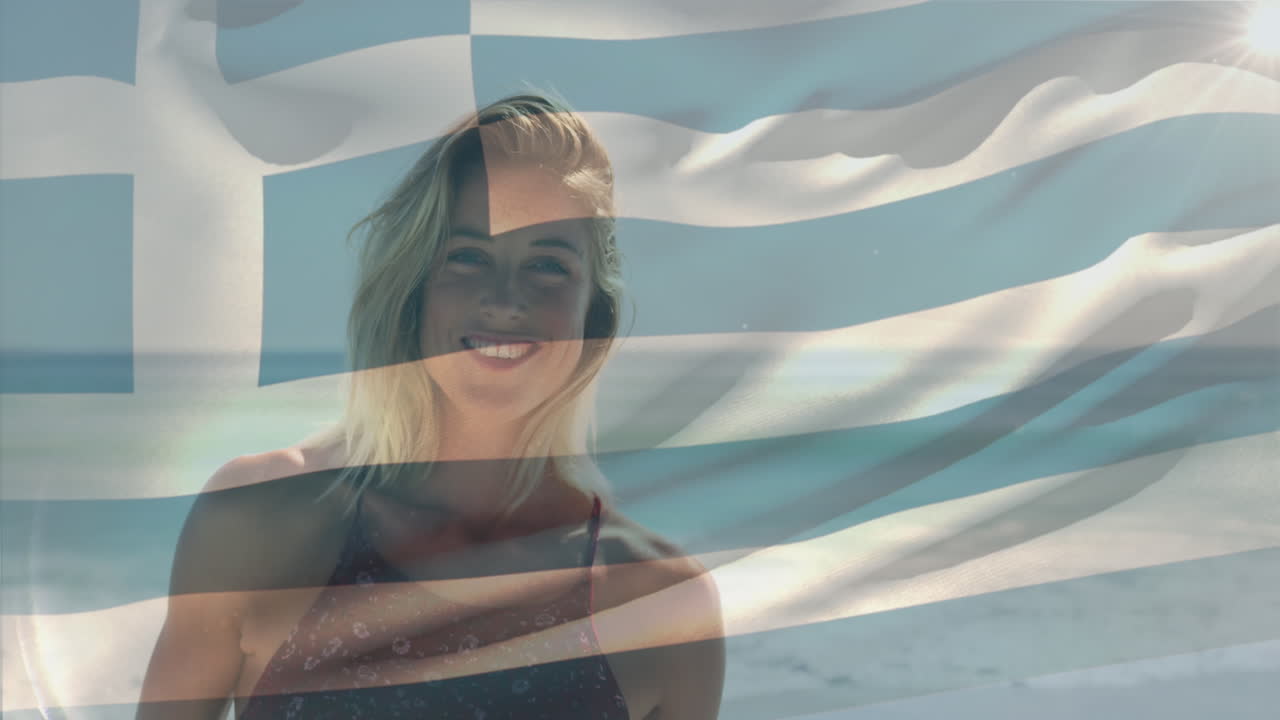 animación de la bandera de grecia ondeando sobre una mujer caucásica sonriente de pie contra el mar en la playa