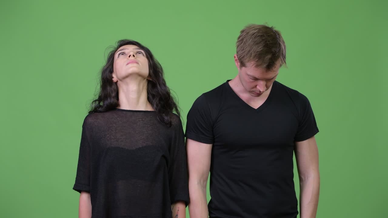 Young couple looking in different directions together