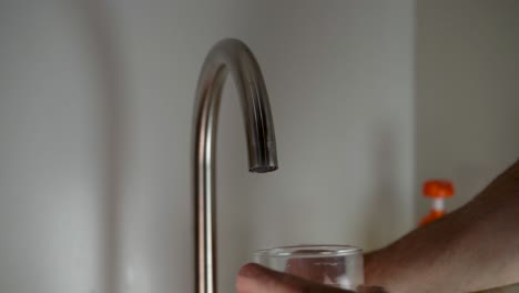 Close-up--of-man-filling-glass-of-water