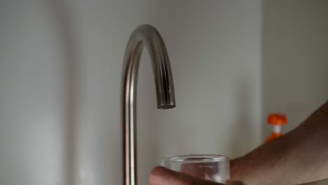 primer plano, de, hombre, llenado, vaso de agua