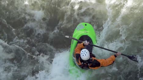 kayaker surfing a wave with bird's eye view looking down