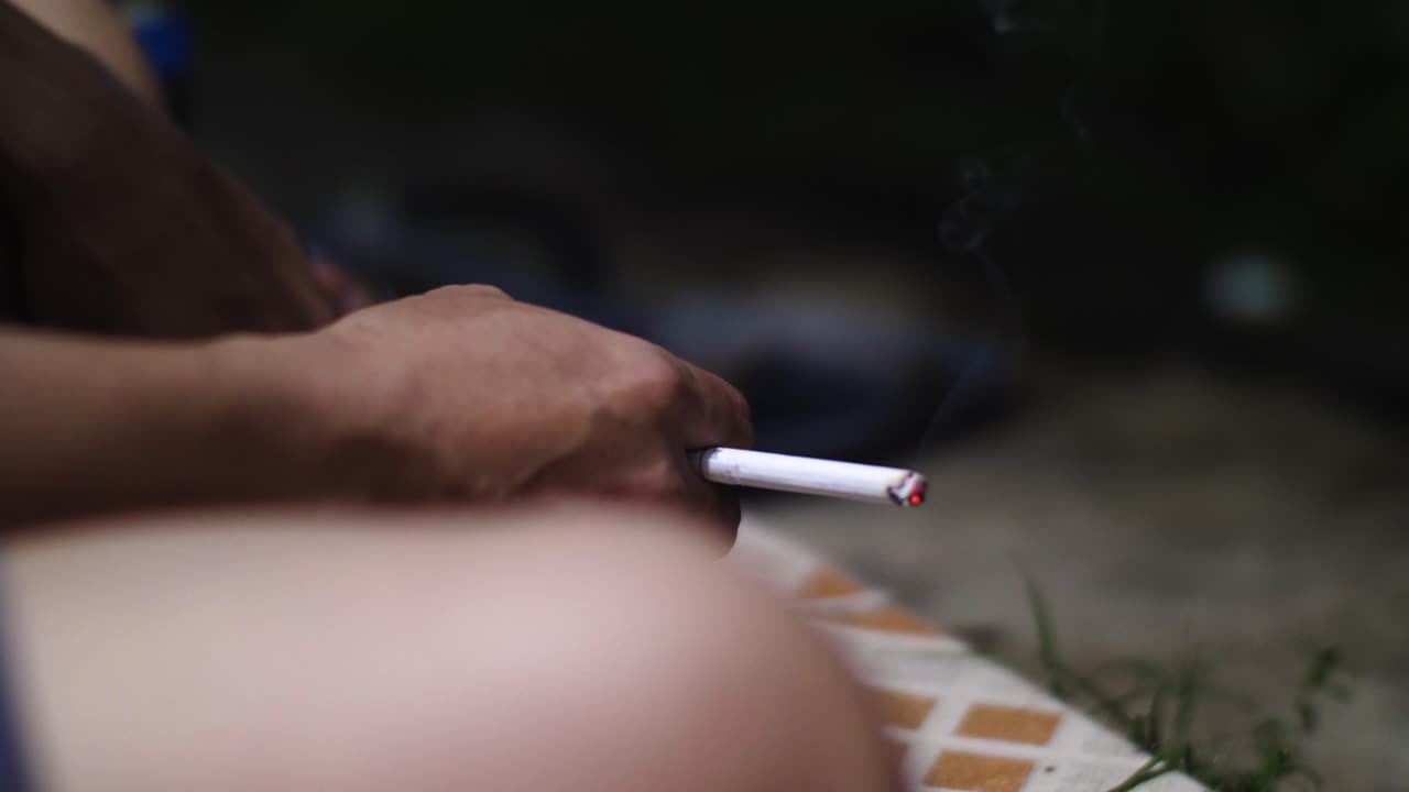 primer plano de la mano y el cigarrillo