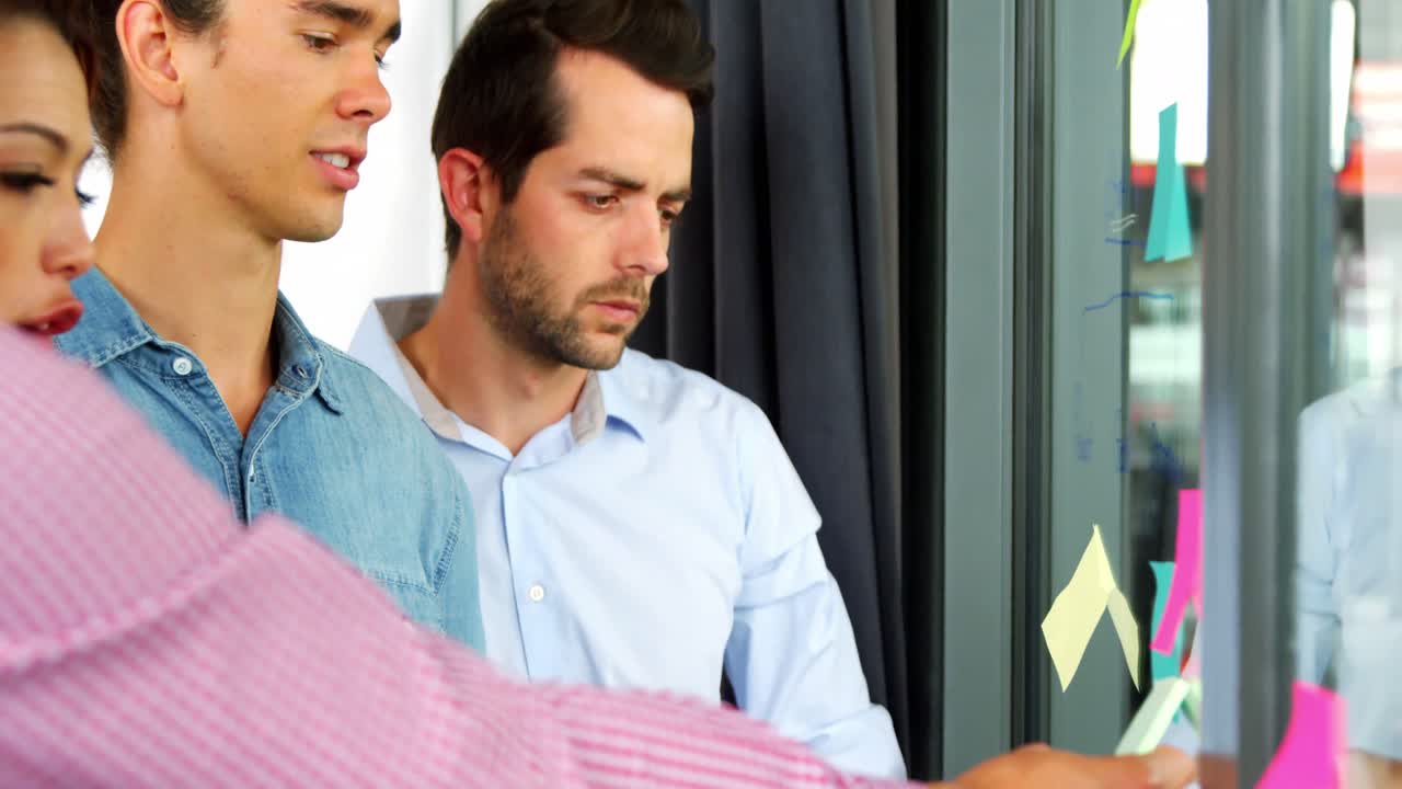 비즈니스 임원 들 이 스티키 노트 에 대해 논의 하고 있다