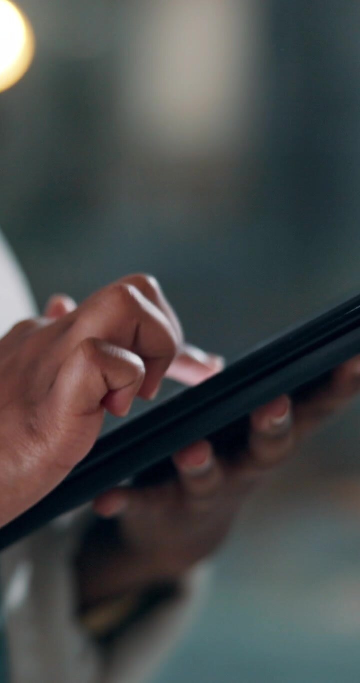 Primo piano di una persona che utilizza un tablet in un ufficio moderno
