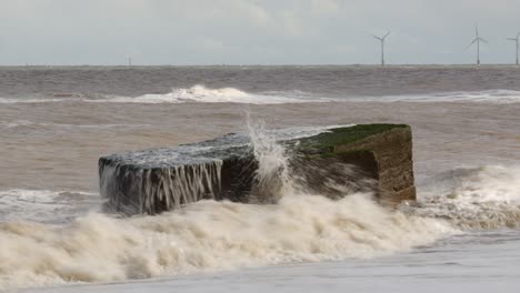 olas rompiendo sobre un pilar del siglo de la segunda guerra mundial en la playa de hemsby