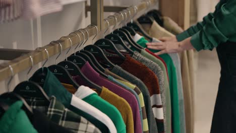 woman checks out recycled second-hand clothes shop