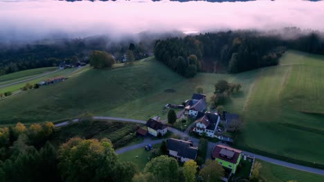 Small,-remote-village-nestled-in-a-valley-between-rolling-green-hills