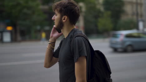 Hombre-Caminando-En-La-Calle-Budapest,-Sacando-El-Teléfono-Del-Bolsillo-Para-Hablar