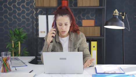 una mujer de negocios agresiva hablando por teléfono enojada.