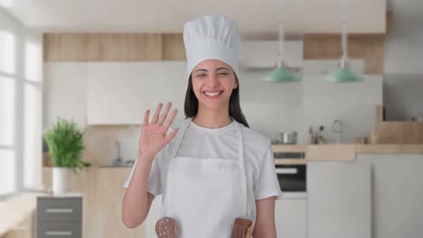 Happy-Indian-female-professional-chef-waving-Hi-to-the-camera