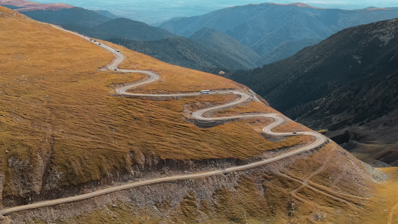 Aerial drone view of nature in Romania. Carpathian mountains, sparse vegetation, Transalpina road with cars