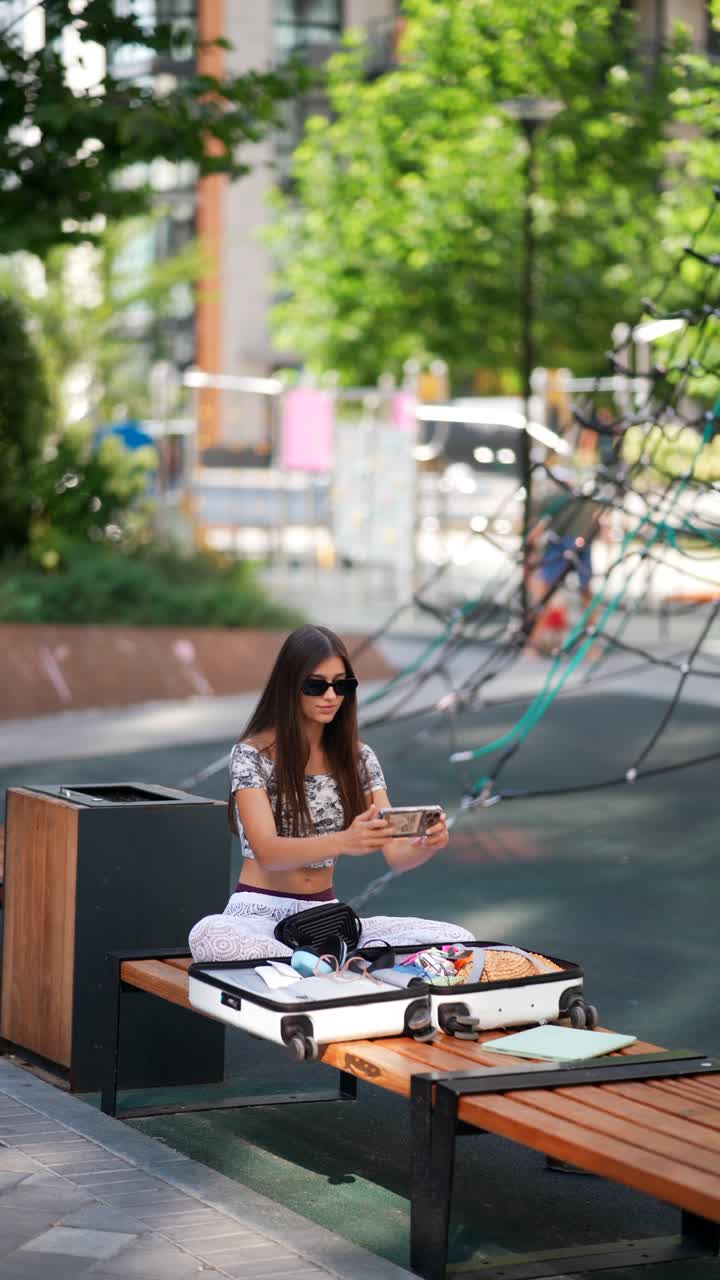 mujer joven con equipaje en un parque