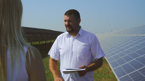 man and woman talking at solar power plant
