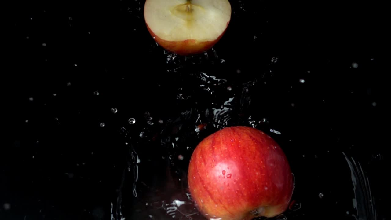 Æble falder i vand. Slowmotion