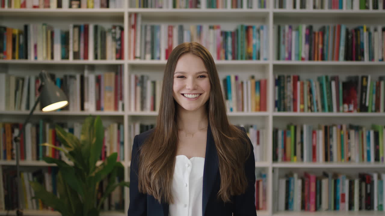 ritratto di una giovane bella donna in piedi in biblioteca studente sorridente ridendo studio apprendimento