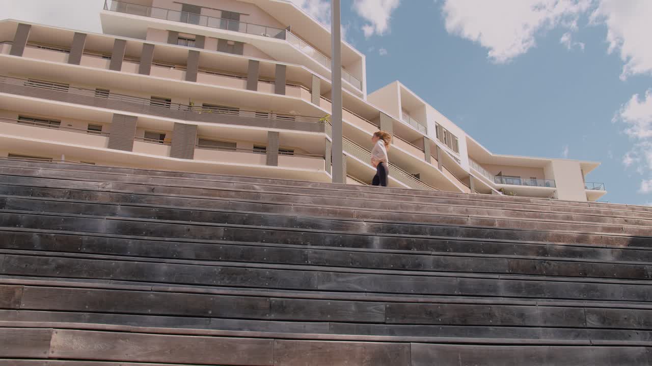 bella joven trotando cerca de edificios de apartamentos con pantalones de yoga