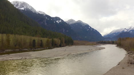 scenic aerial drone view flying through a majestic mountain valley in the british columbia wilderness