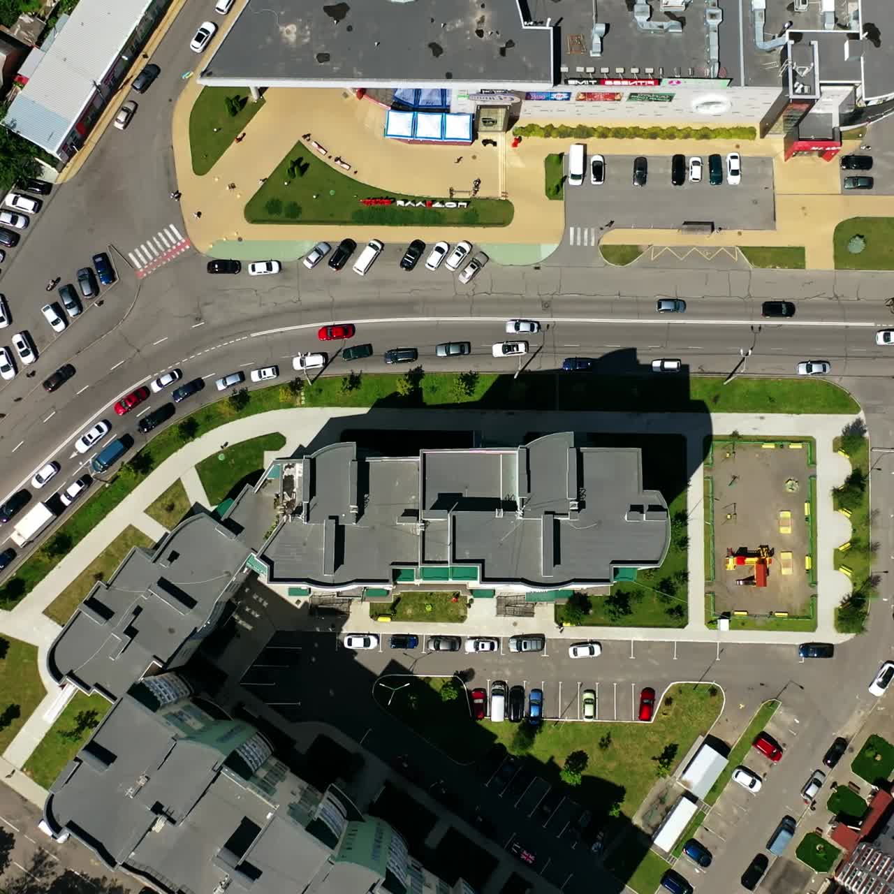 Modern city. Urban district with architecture and road filled with moving cars. View from above. Motion camera top down.